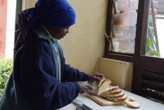 37 Tanzania portretten boerinnen farmfriends fotografie brood snijden DSF5105 525x352